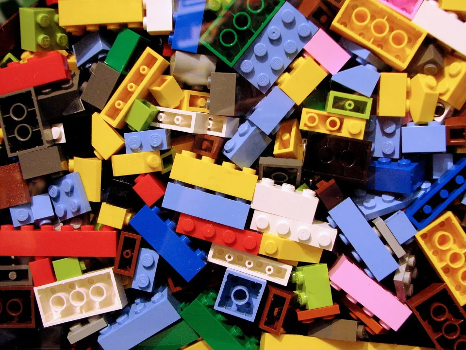 Фотография: россыпь разноцветных кубиков Lego — красных, синих, жёлтых, зелёных и розовых