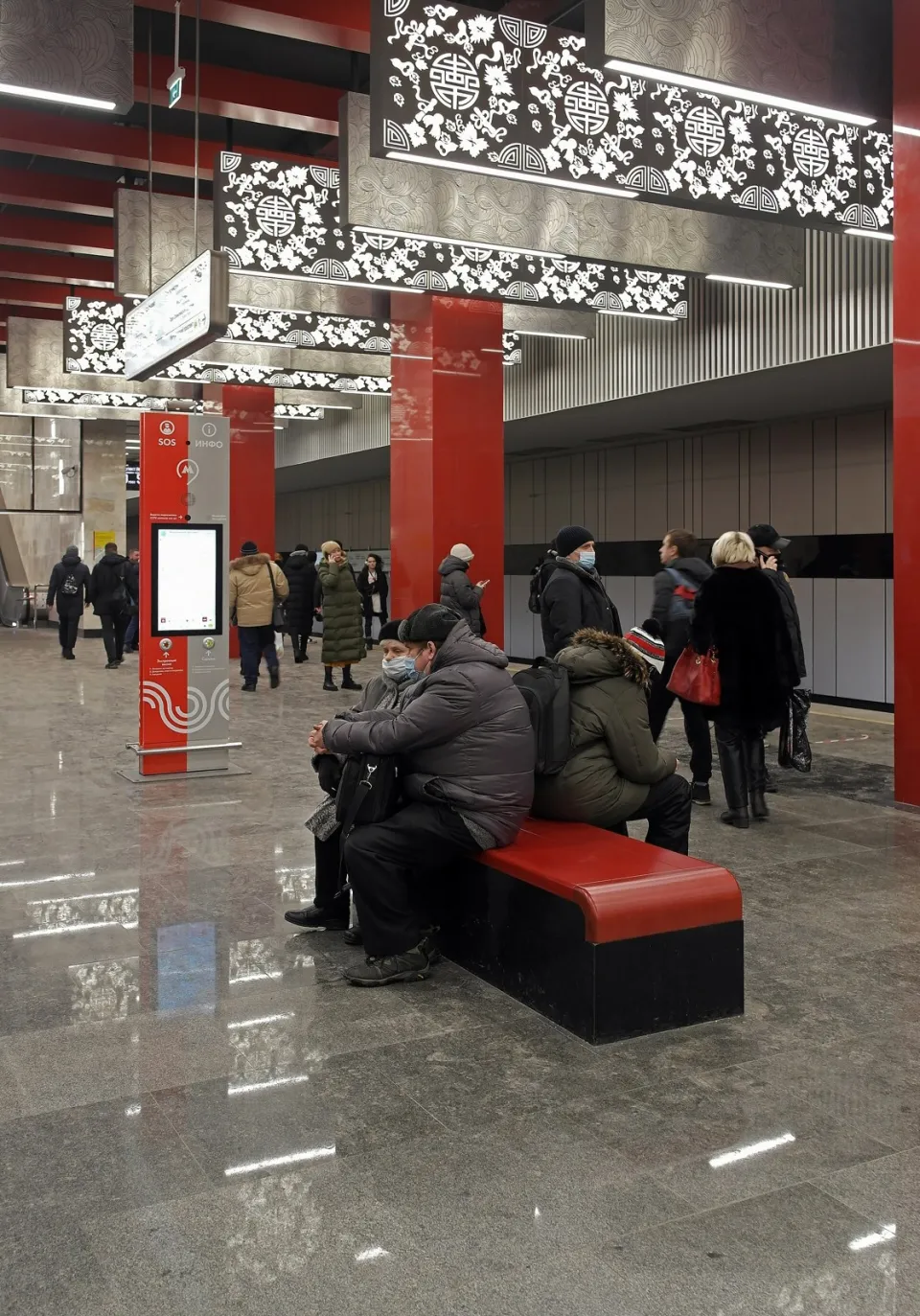 Светлый вестибюль станции метро с красными колоннами и узорными светильниками