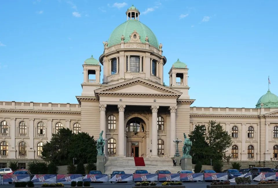 Монументальное здание с колоннами и зелёным куполом на площади в Белграде