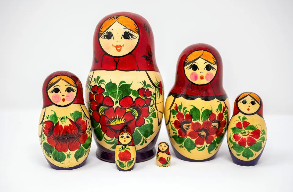 Пять расписных матрёшек разного размера с красными цветами